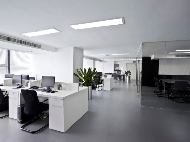 An office thats clean and decorated with white.