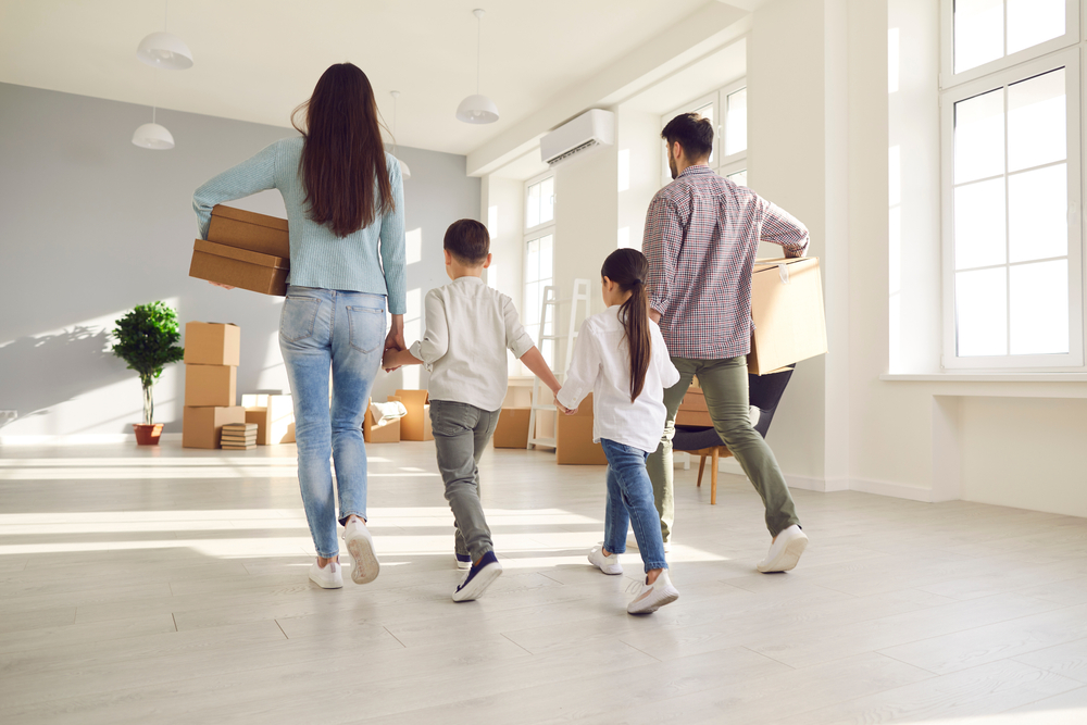 Mom, dad and their son and daughter waling into an empty house.