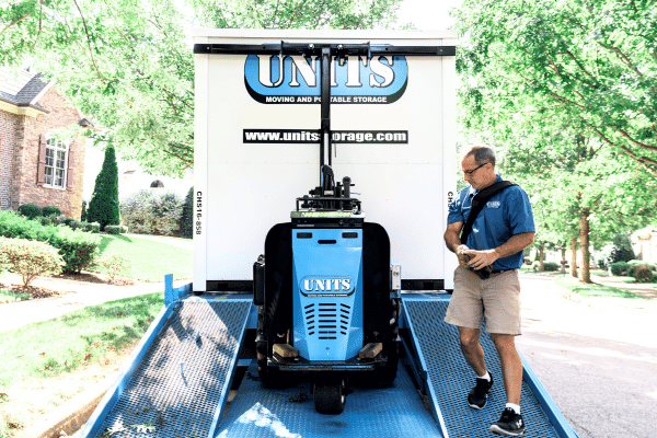 Man using a ROBO-UNIT to move a UNITS Moving and Portable Storage container off the delivery truck.