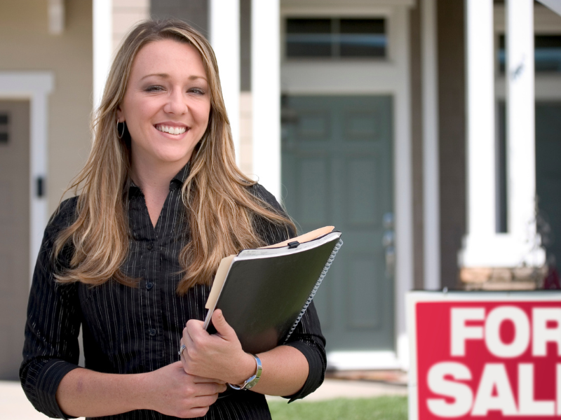 Realtor in front of a house for sale