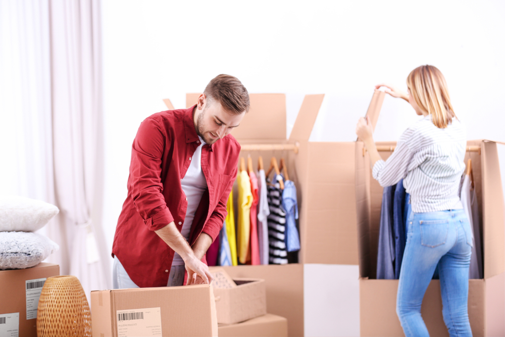 Man and woman packing their clothes away in preparation for their move.