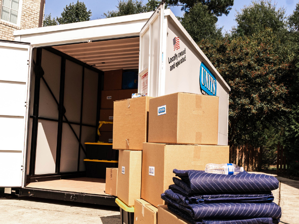 UNITS Moving and Portable Storage of Phoenix container in a driveway with carboard boxes stacked up outside of the container.