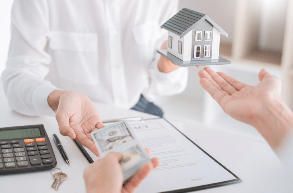 Person paying money for a house miniature.