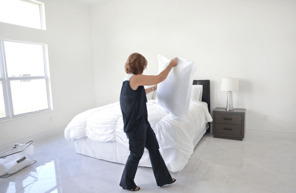 Woman fixing up her bed.