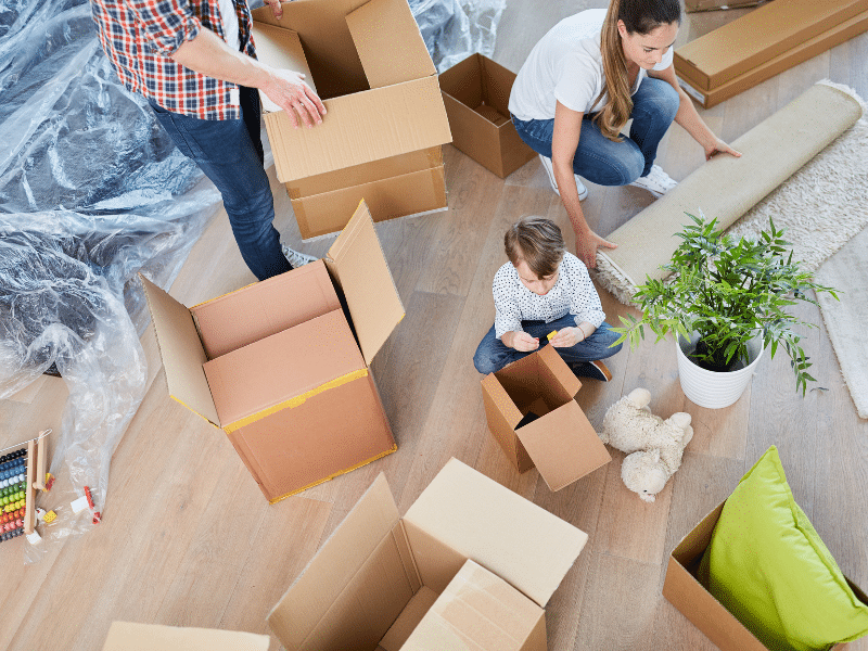 Family working together to pack their belongings in cardboard boxes.