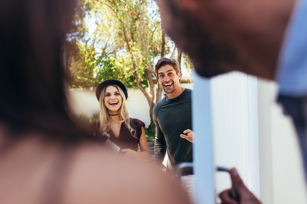 Couple excitedly greeting their friends.