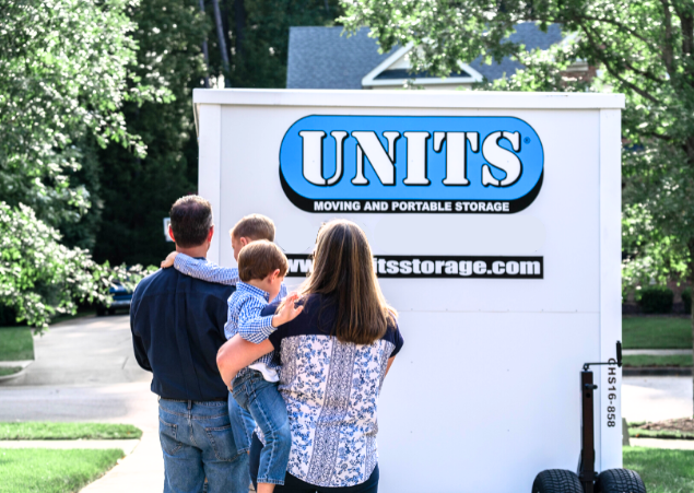 A family standing in front of a UNITS of San Diego's portable storage container after using it for moving.