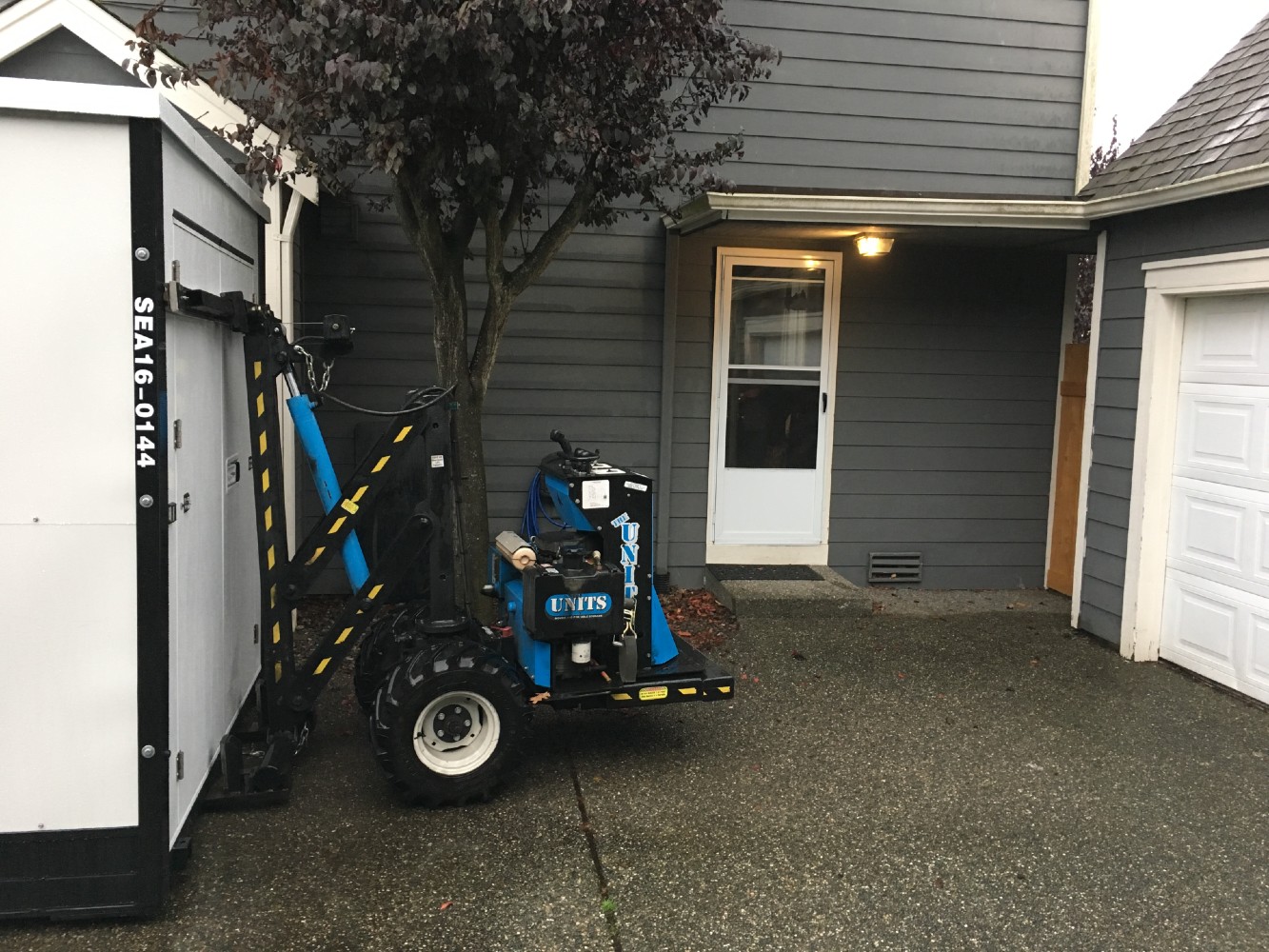 ROBO-UNIT moving a UNITS Moving and Portable Storage container into a driveway.