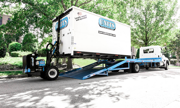 UNITS Moving and Portable Storage container being moved off a UNITS truck by a ROBO-UNIT.