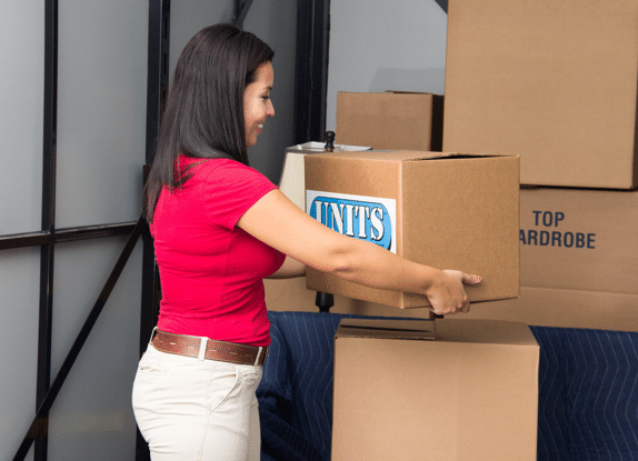 Woman putting a box with the units logo inside a storage container.