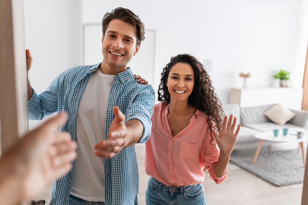 Couple meeting someone at their front door.