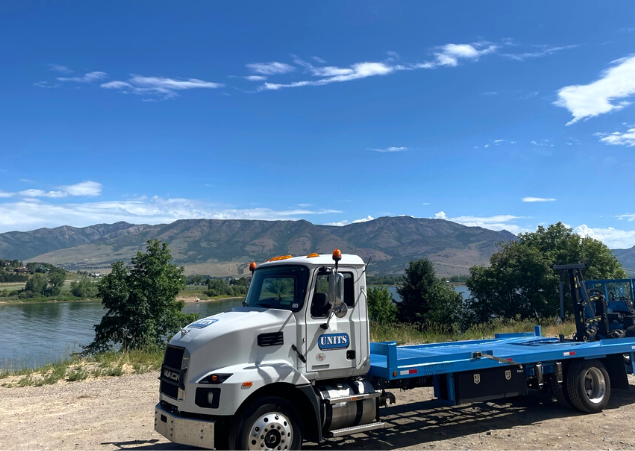 Units Of Utah truck parked on the side of the road by the water.