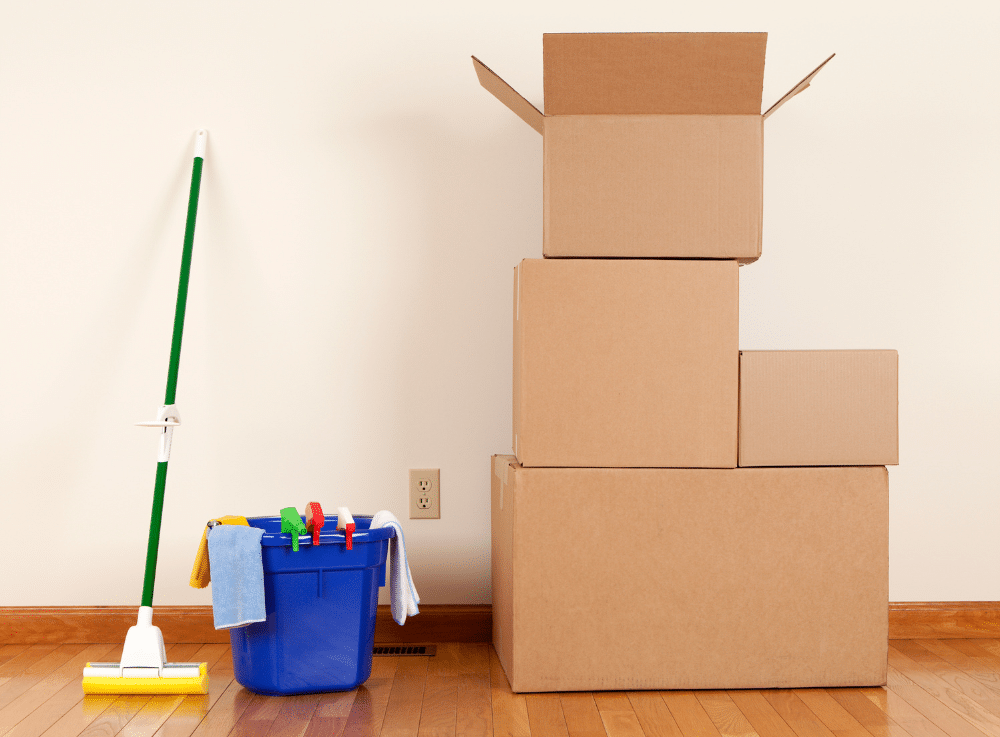 Boxes and cleaning equipment on the floor in a room.