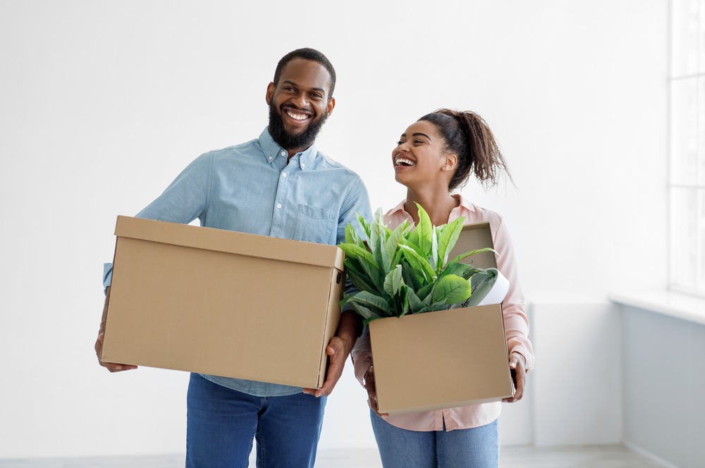 Couple holding boxes while walking.