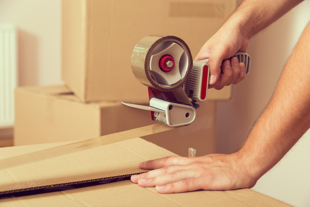 Man packing boxes using tape.