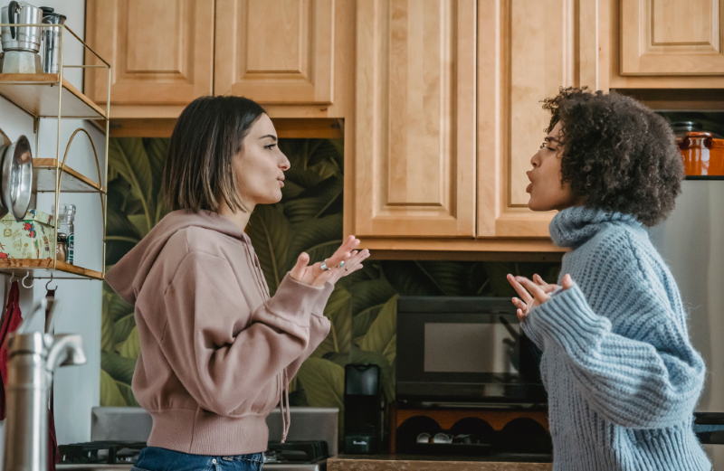 Two women arguing in a kitchen.