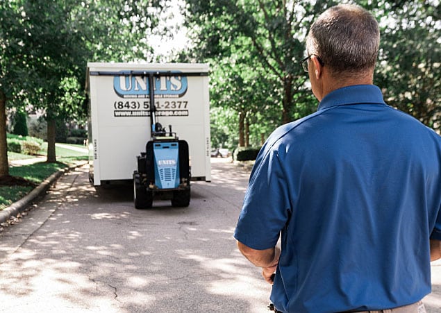 Guy looking at a UNITS moving and portable storage container that is in the process of being delivered